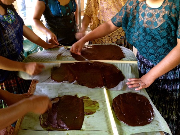 women spreading chocolate on banana leaves