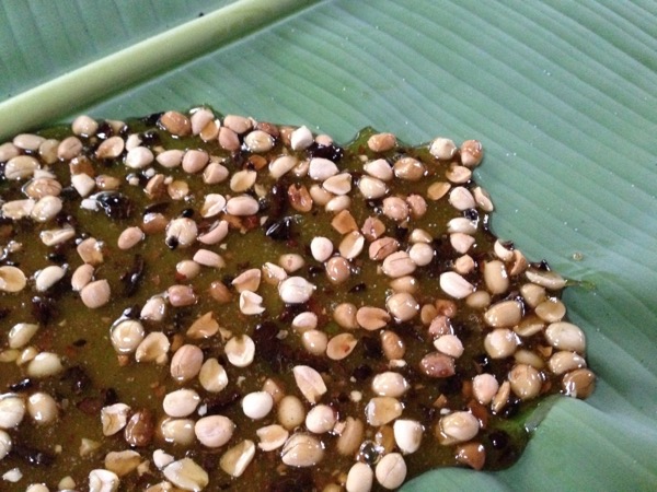 nib and peanut brittle drying on banana leaves