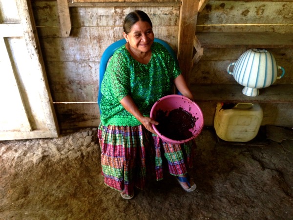 woman holding a bowl of ground cacao