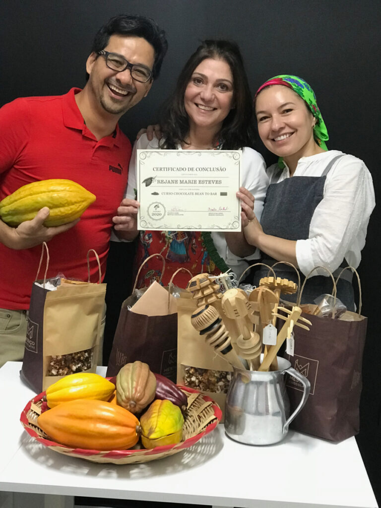 three people in front of cacao and with a certificate