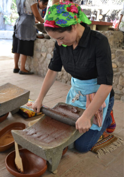 woman grinding on a metate this is on the floor