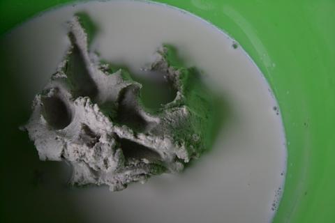 Dissolving masa in milk in a green bowl
