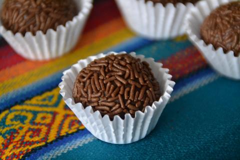 chocolate brigadeiro in a paper cup on a colored table