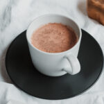cup of hot chocolate in a white cup on a black plate