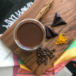 cup of coffee on a wooden board with chocolate and orange zest