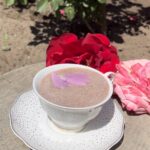 Cup of chocolate outside next to roses
